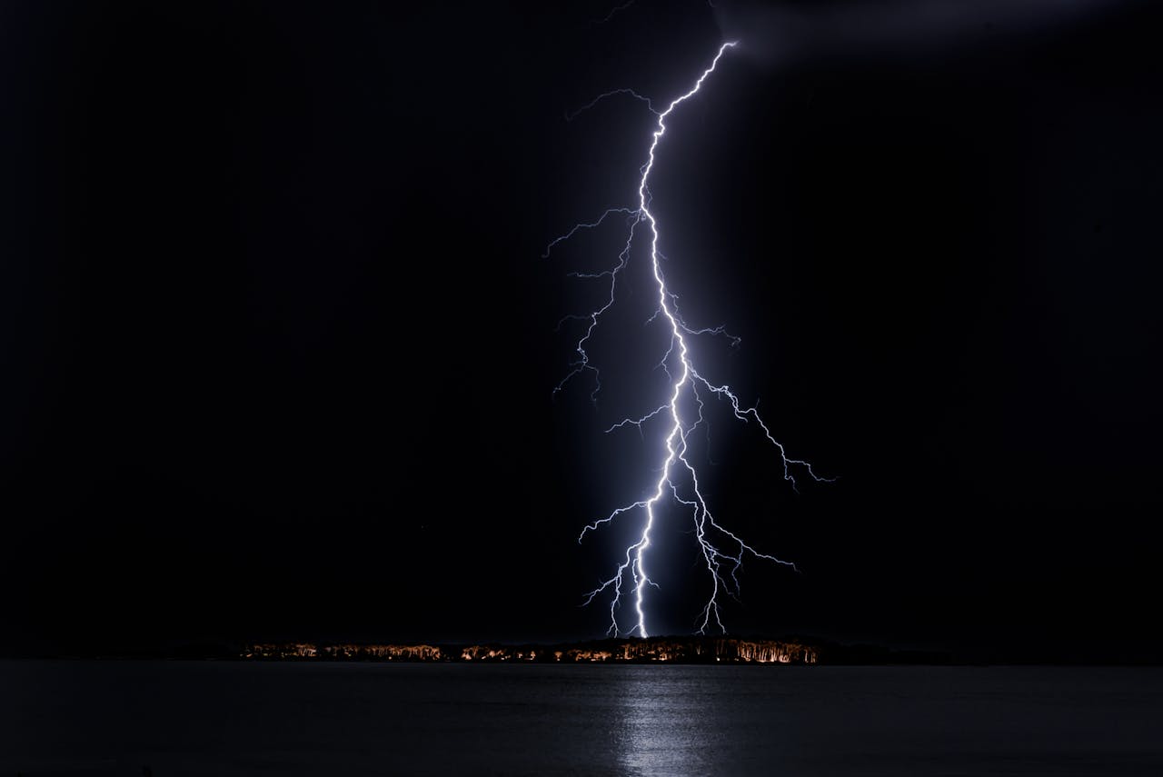Stunning nighttime lightning bolt captured over ocean, casting eerie glow in Uruguay.